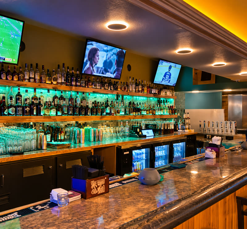 The back bar with TVs and backlit bottles