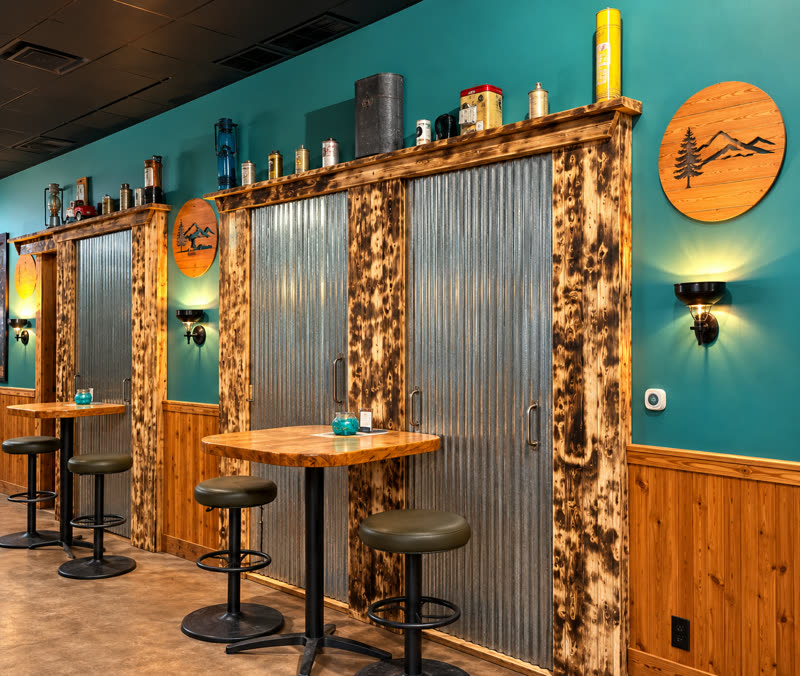 High-top tables along the teal wall